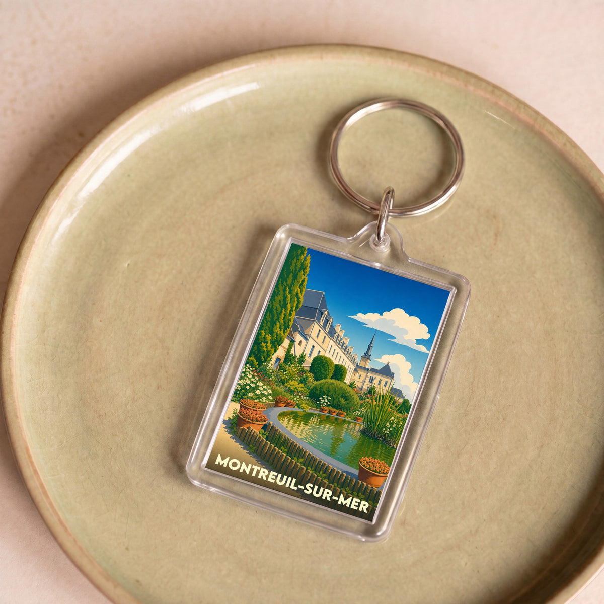 Porte-clés souvenir de la ville de Montreuil-sur-Mer avec une illustration stylisée.
