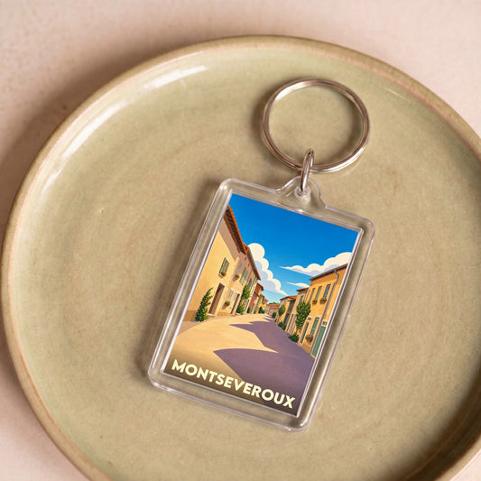 Porte-clés souvenir de la ville de Montseveroux avec une illustration stylisée d'une rue ensoleillée.