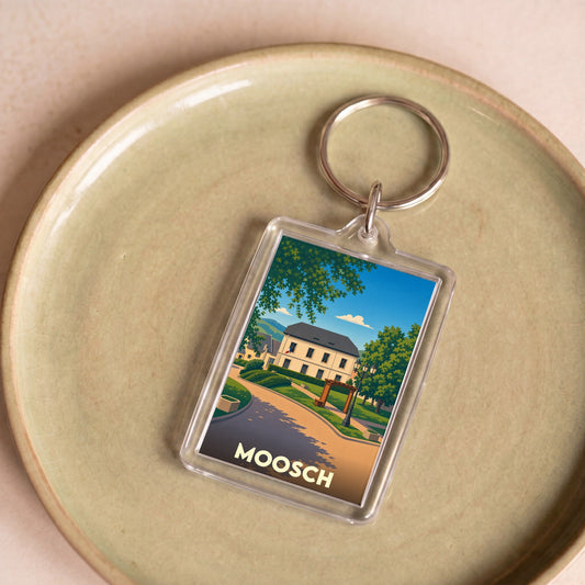 Porte-clés souvenir de la ville de Moosch avec une illustration stylisée.