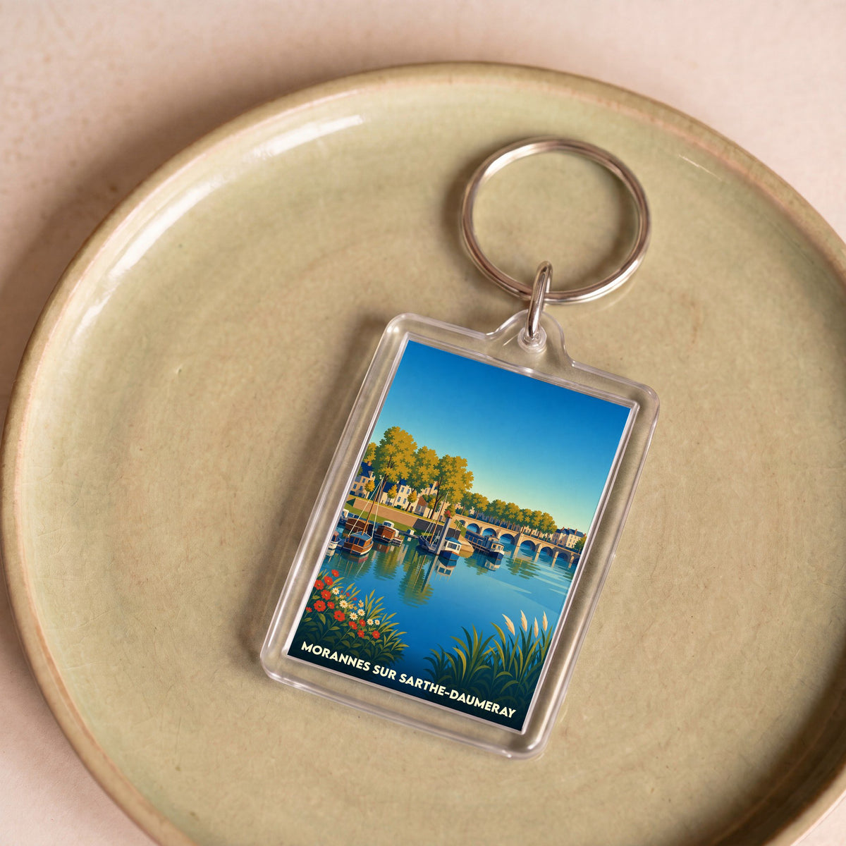 Porte-clés souvenir de la ville de Morannes sur Sarthe-Daumeray avec une illustration stylisée.