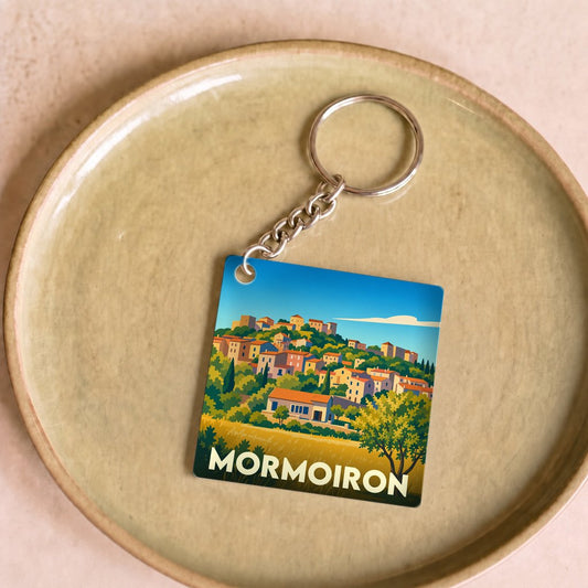 Porte-clés souvenir de la ville de Mormoiron avec une illustration stylisée d'un village perché.