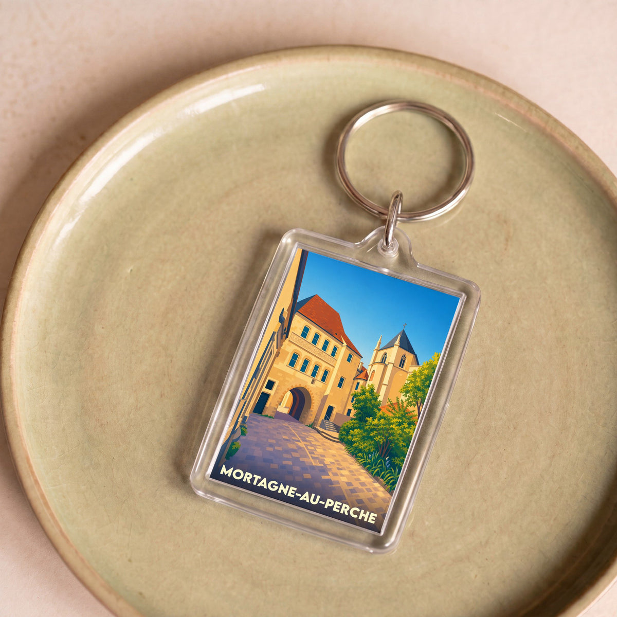 Porte-clés souvenir de la ville de Mortagne-au-Perche avec une illustration stylisée.