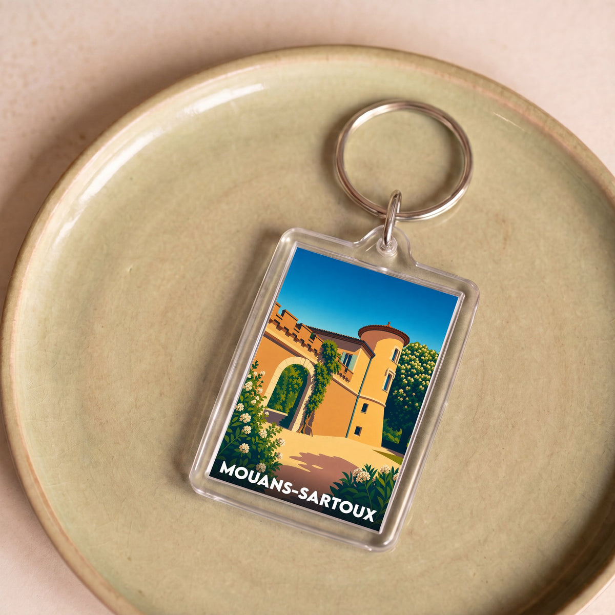 Porte-clés souvenir de la ville de Mouans-Sartoux avec une illustration stylisée de son château.