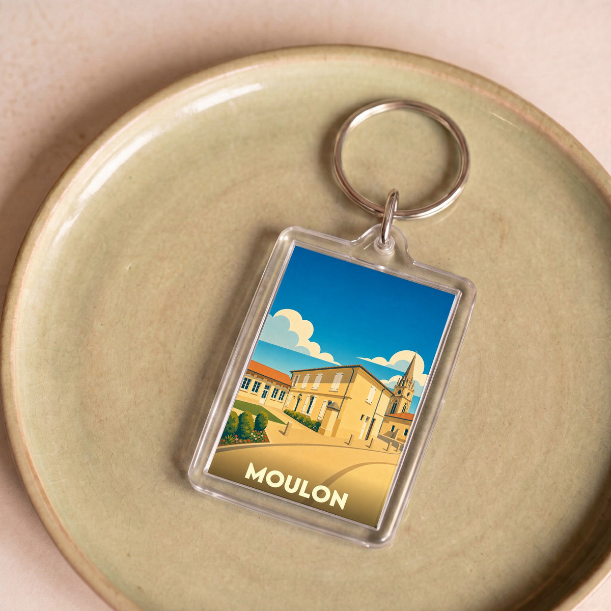 Porte-clés souvenir de la ville de Moulon avec une illustration stylisée.
