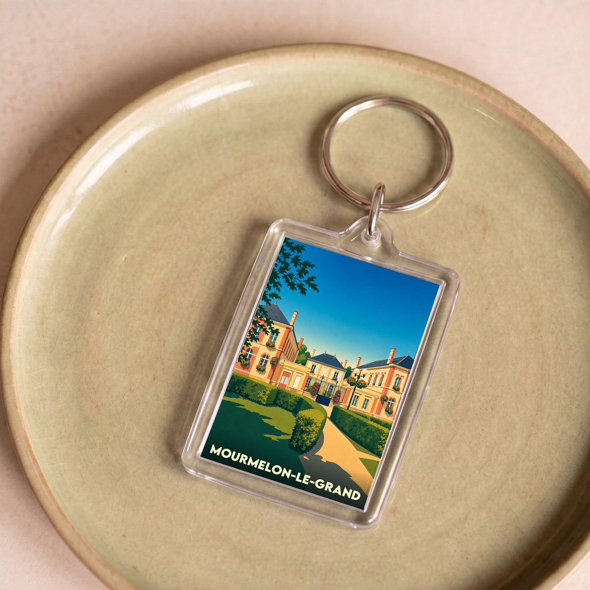 Porte-clés souvenir de la ville de Mourmelon-le-Grand avec une illustration stylisée.