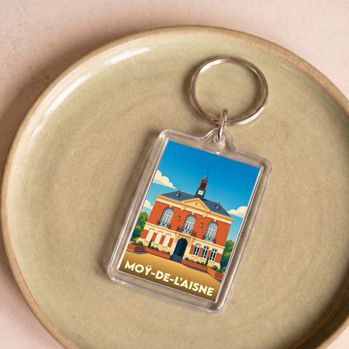 Porte-clés souvenir de la ville de Moÿ-de-l'Aisne avec une illustration stylisée de sa mairie.