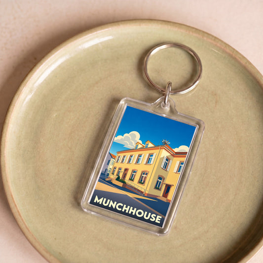 Porte-clés souvenir de la ville de Munchhouse avec une illustration stylisée d'un bâtiment coloré.