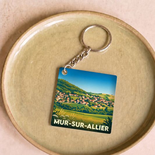 Porte-clés souvenir de la ville de Mur-sur-Allier avec une illustration stylisée de son paysage vallonné.