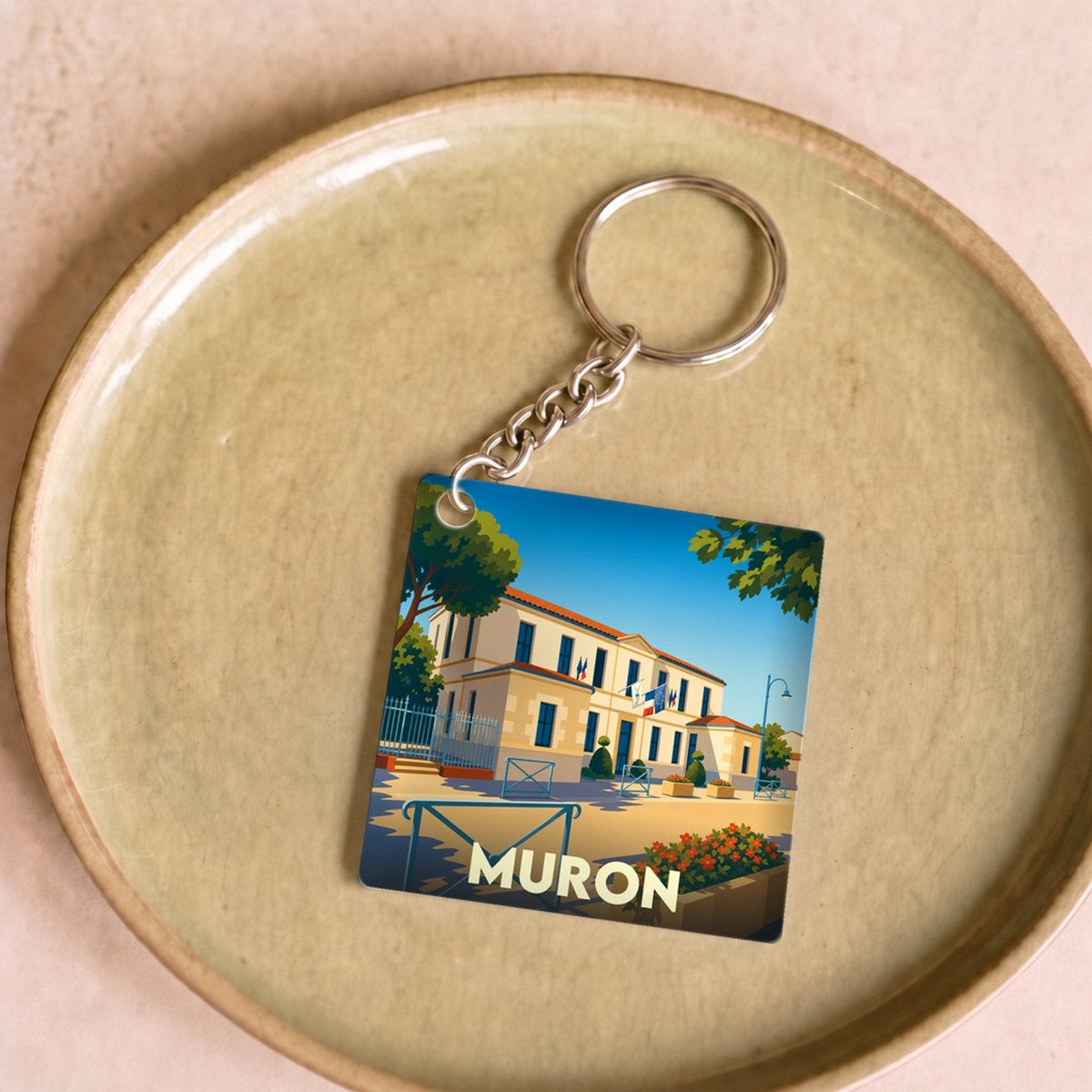 Porte-clés souvenir de la ville de Muron avec une illustration stylisée.