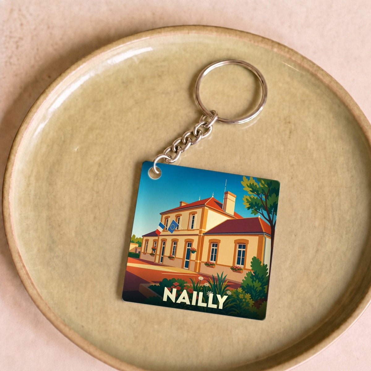 Porte-clés souvenir de la ville de Nailly avec une illustration stylisée de sa mairie.