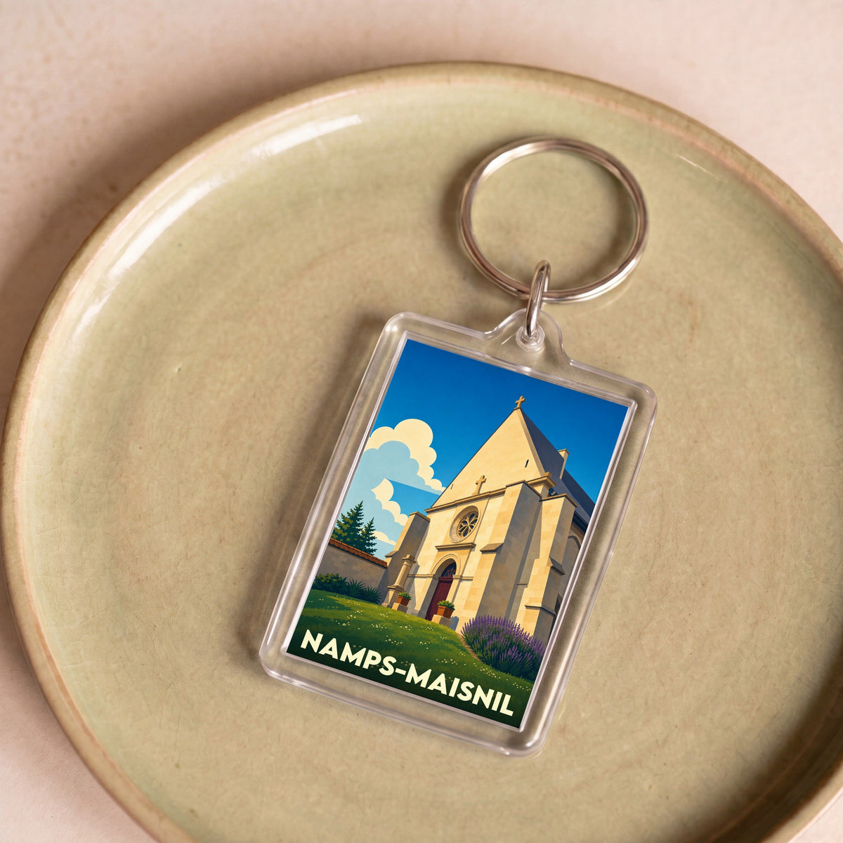 Porte-clés souvenir de la ville de Namps-Maisnil avec une illustration stylisée de son église.