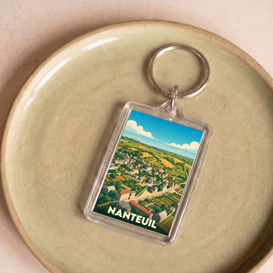 Porte-clés souvenir de la ville de Nanteuil avec une illustration stylisée d'un paysage rural.