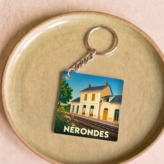 Porte-clés souvenir de la ville de Nérondes avec une illustration stylisée de sa gare ferroviaire.