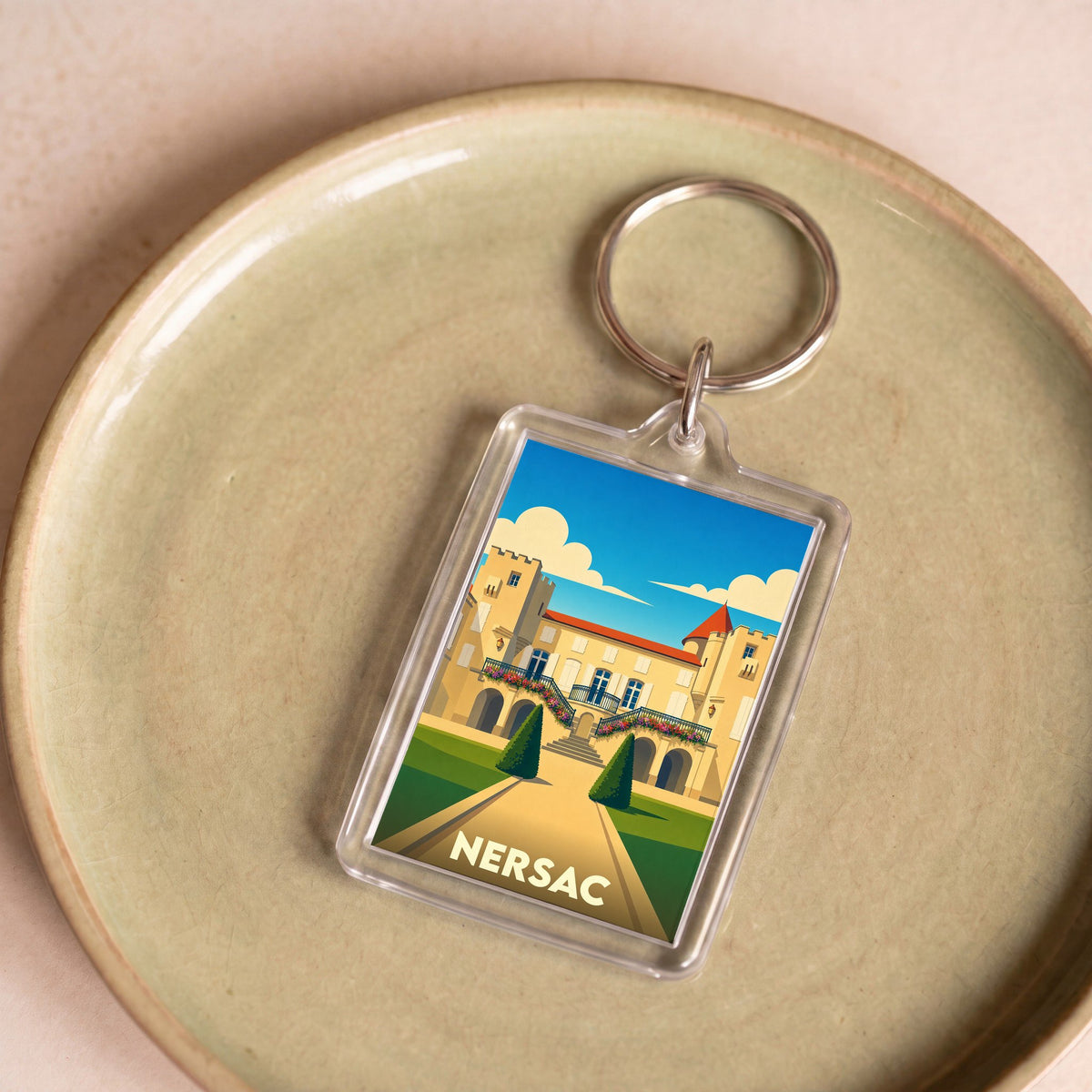 Porte-clés souvenir de la ville de Nersac avec une illustration stylisée de son château.