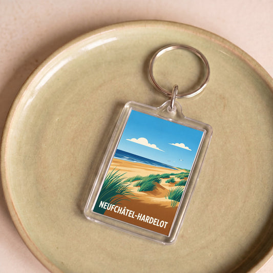 Porte-clés souvenir de la ville de Neufchâtel-Hardelot avec une illustration stylisée de dunes et de mer.