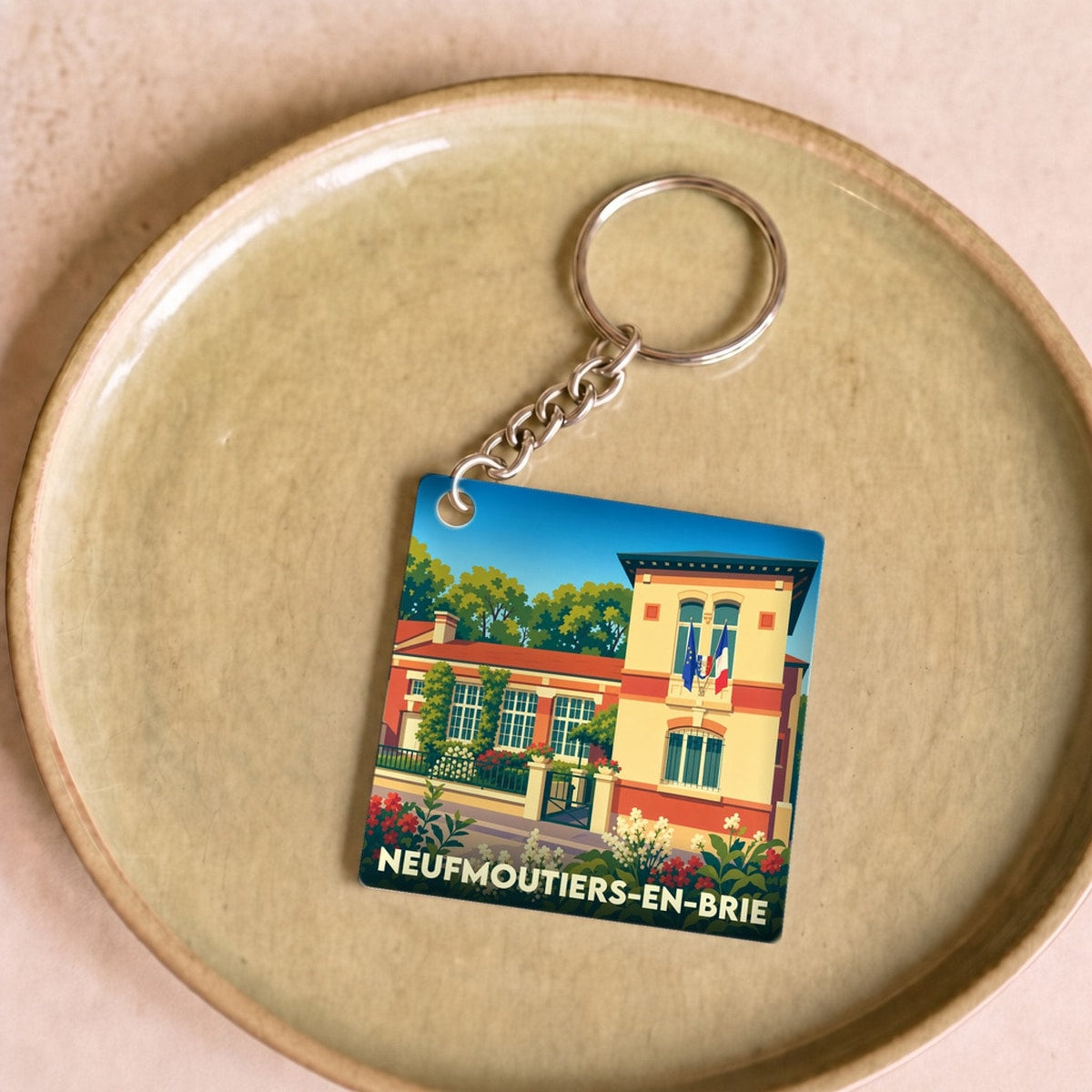 Porte-clés souvenir de la ville de Neufmoutiers-en-Brie avec une illustration stylisée.