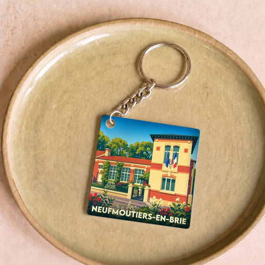 Porte-clés souvenir de la ville de Neufmoutiers-en-Brie avec une illustration stylisée.