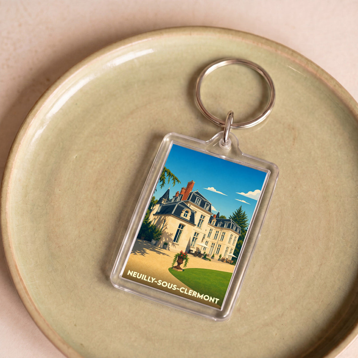 Porte-clés souvenir de la ville de Neuilly-sous-Clermont avec une illustration stylisée d'un château.