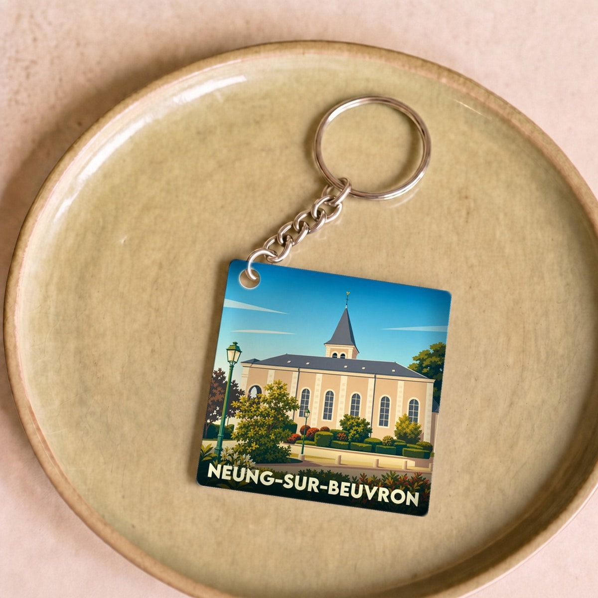 Porte-clés souvenir de la ville de Neung-sur-Beuvron avec une illustration stylisée.