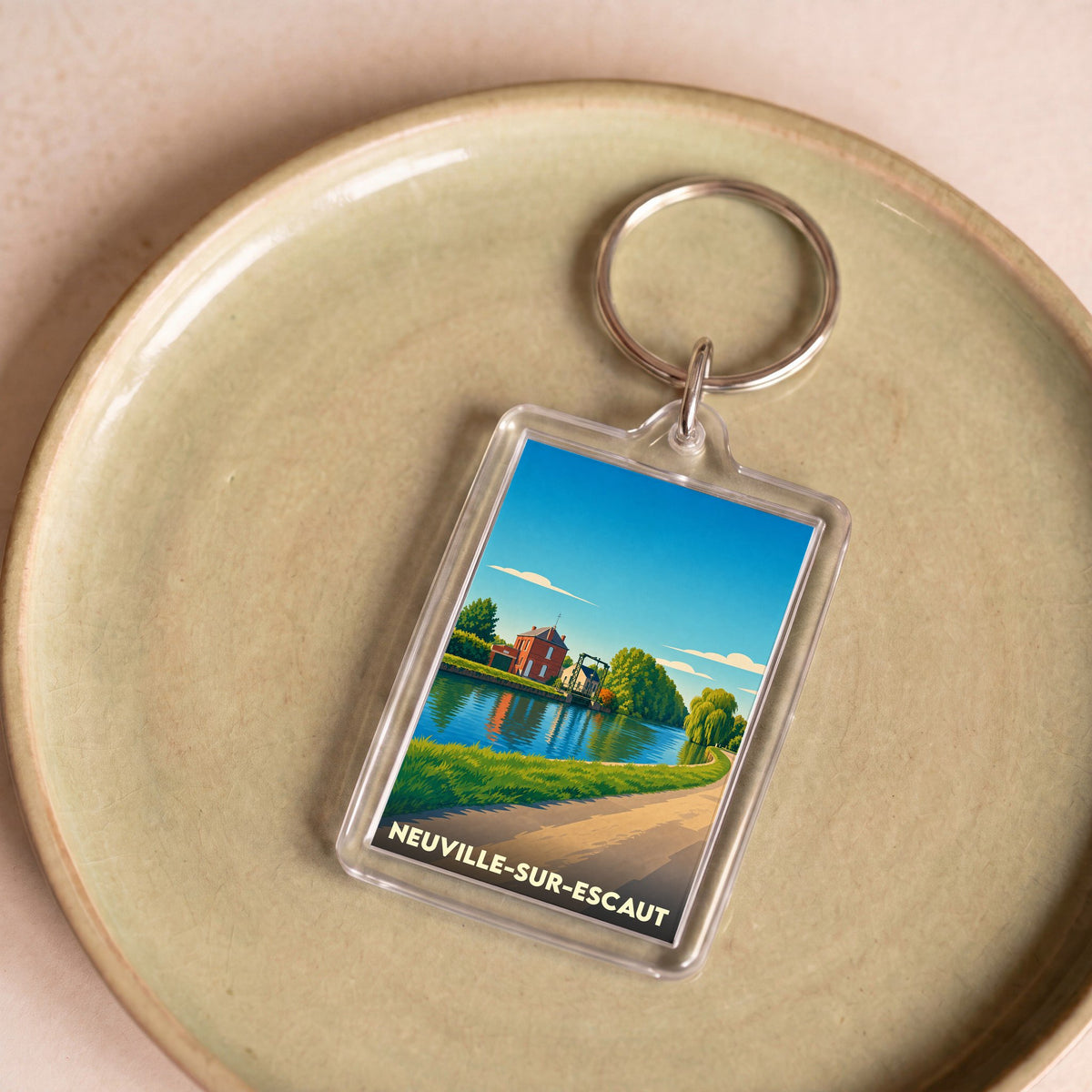 Porte-clés souvenir de la ville de Neuville-sur-Escaut avec une illustration stylisée des bords de l'Escaut.