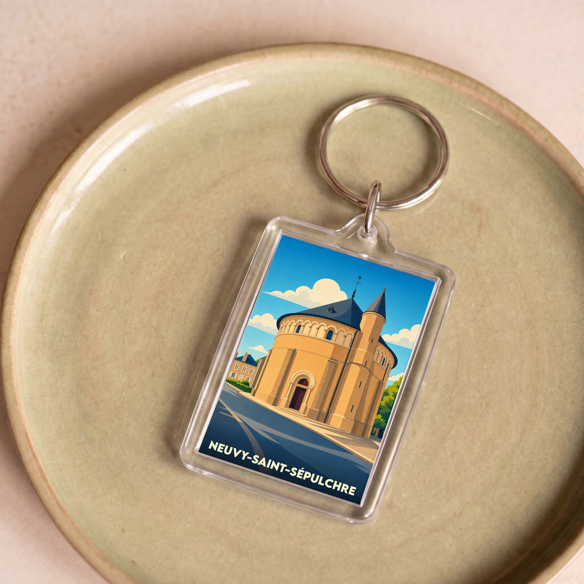 Porte-clés souvenir de la ville de Neuvy-Saint-Sépulchre avec une illustration stylisée de sa basilique.