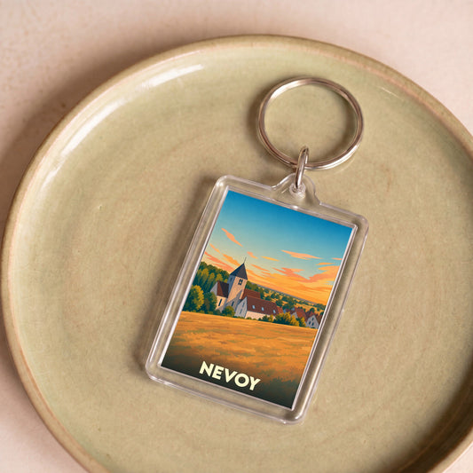 Porte-clés souvenir de la ville de Nevoy avec une illustration stylisée d'un paysage rural au coucher du soleil.