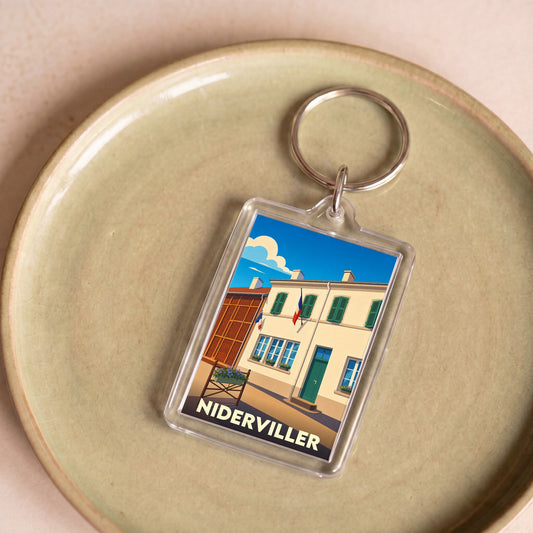 Porte-clés souvenir de la ville de Niderviller avec une illustration stylisée d'un bâtiment typique.