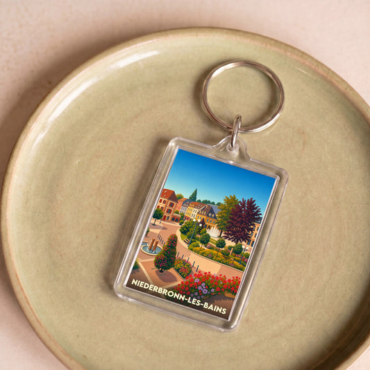 Porte-clés souvenir de la ville de Niederbronn-les-Bains avec une illustration stylisée et colorée.