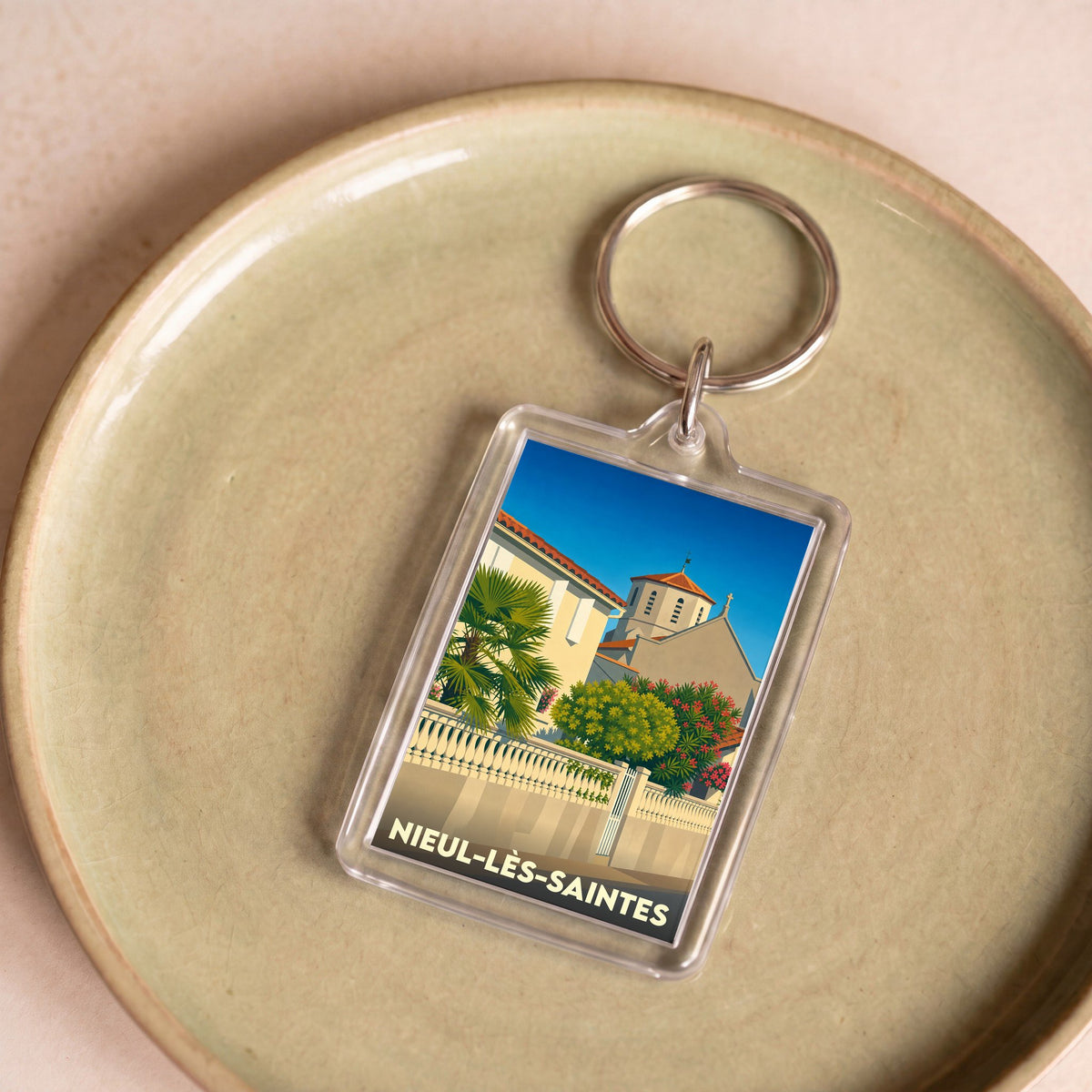Porte-clés souvenir de la ville de Nieul-lès-Saintes avec une illustration stylisée.