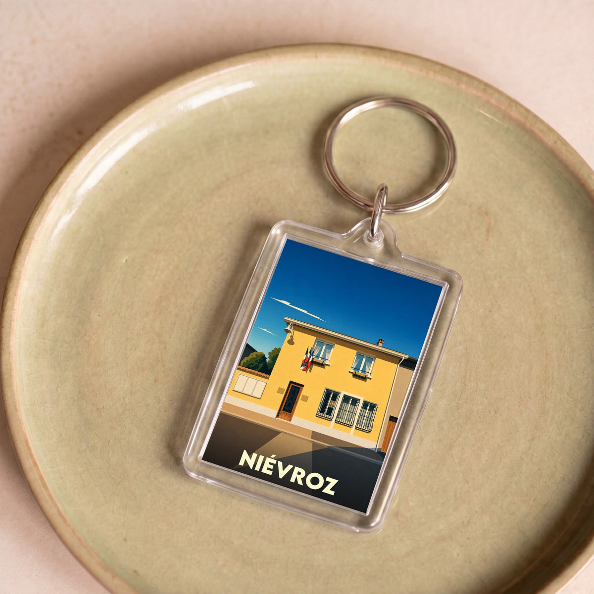Porte-clés souvenir de la ville de Niévroz avec une illustration stylisée.
