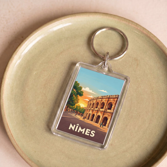Porte-clés souvenir de la ville de Nîmes avec une illustration stylisée de ses arènes romaines.