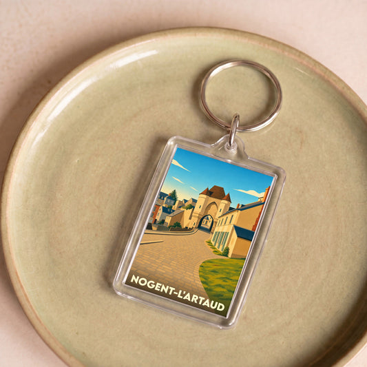 Porte-clés souvenir de la ville de Nogent-l'Artaud avec une illustration stylisée.