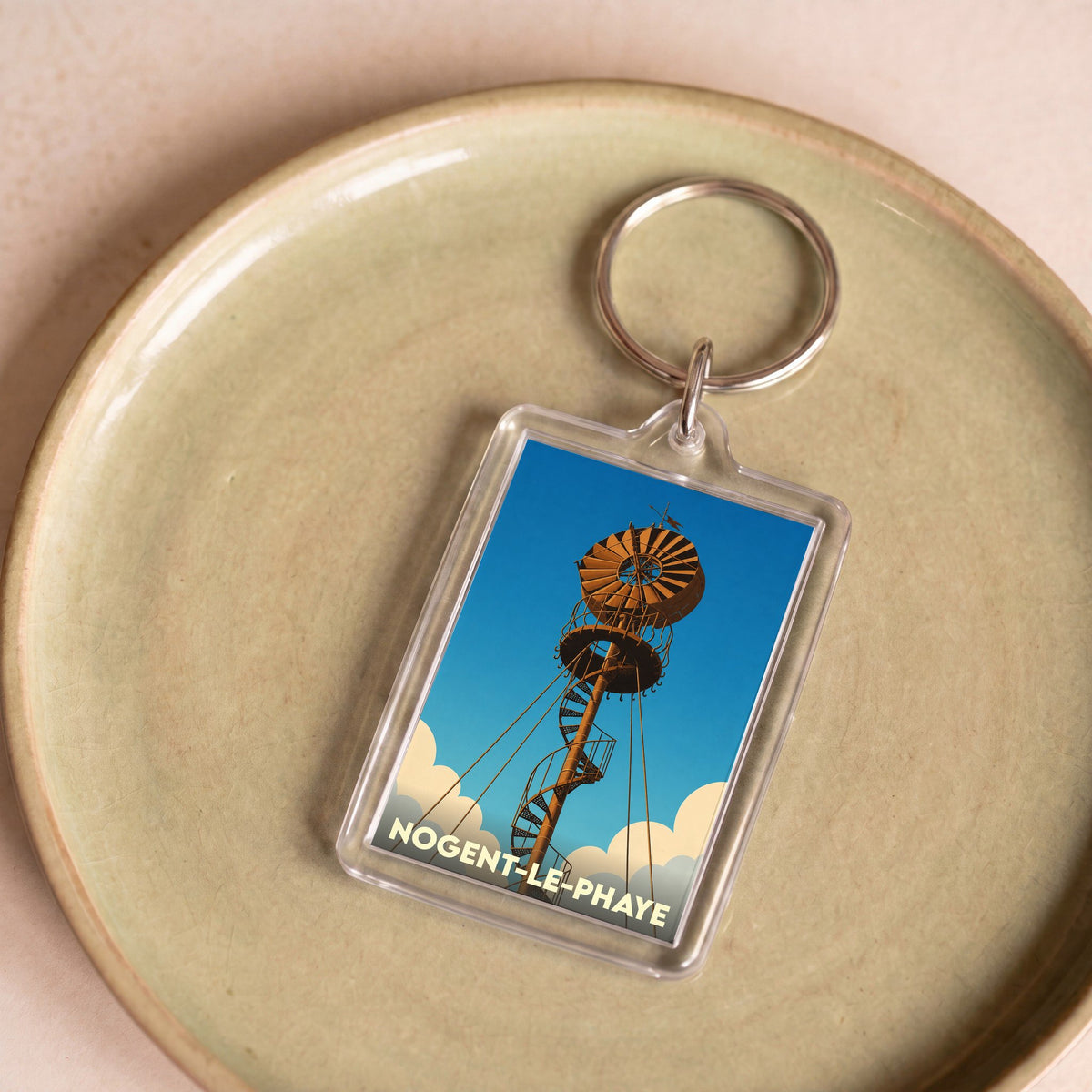 Porte-clés souvenir de la ville de Nogent-le-Phaye avec une illustration stylisée d'une éolienne ancienne.