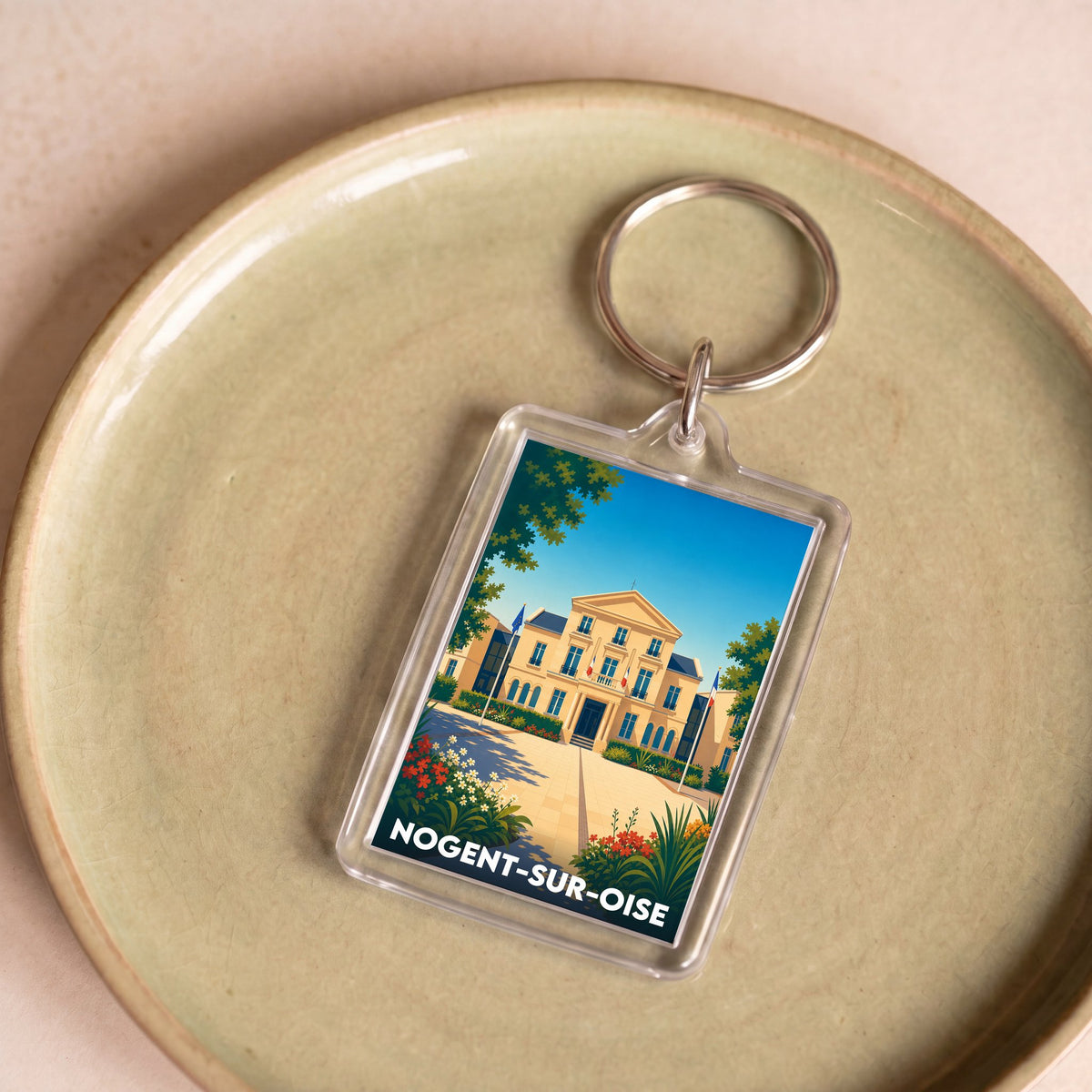 Porte-clés souvenir de la ville de Nogent-sur-Oise avec une illustration stylisée de son hôtel de ville.