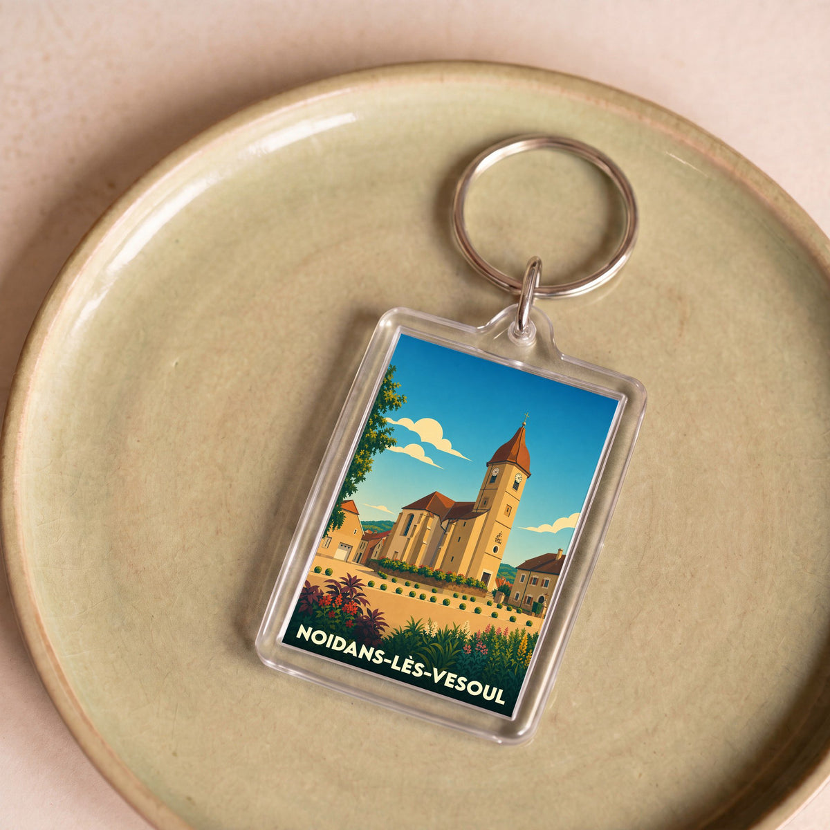 Porte-clés souvenir de la ville de Noidans-lès-Vesoul avec une illustration stylisée.