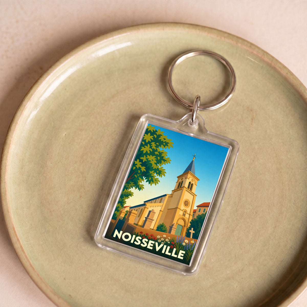 Porte-clés souvenir de la ville de Noisseville avec une illustration stylisée de son église.