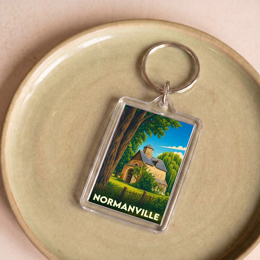 Porte-clés souvenir de Normanville avec une illustration stylisée d'un bâtiment en pierre sous un grand arbre.