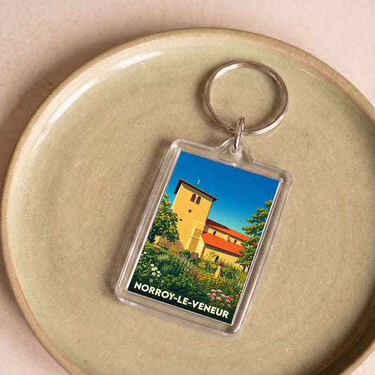Porte-clés souvenir de la ville de Norroy-le-Veneur avec une illustration colorée et stylisée de son église.