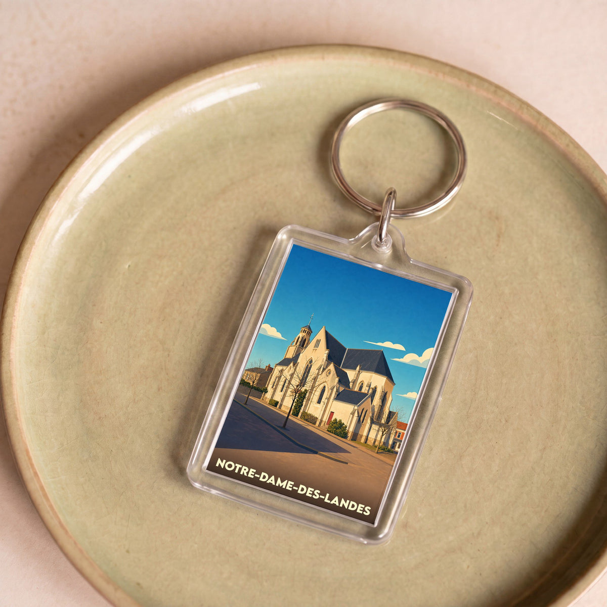 Porte-clés souvenir de la ville de Notre-Dame-des-Landes avec une illustration stylisée de son église.