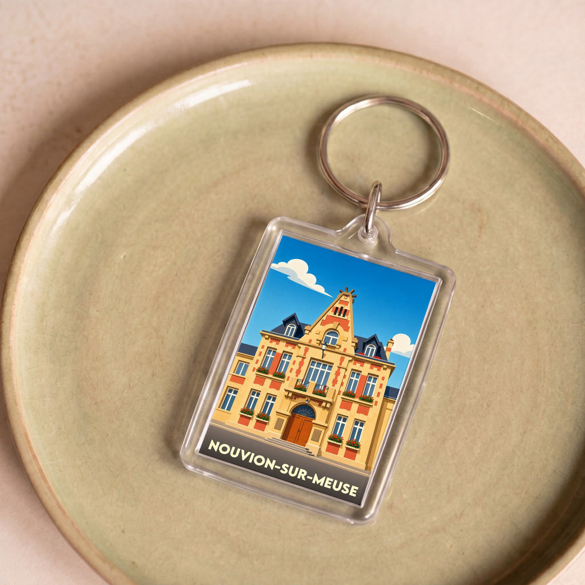 Porte-clés souvenir de la ville de Nouvion-sur-Meuse avec une illustration stylisée de sa mairie.
