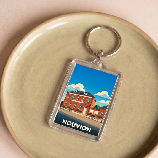 Porte-clés souvenir de la ville de Nouvion avec une illustration stylisée d'un bâtiment historique.