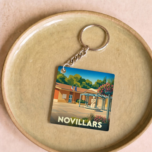 Porte-clés souvenir de la ville de Novillars avec une illustration stylisée.