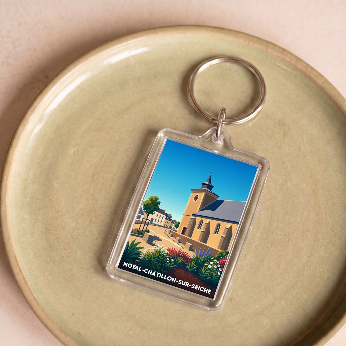 Porte-clés souvenir de la ville de Noyal-Châtillon-sur-Seiche avec une illustration stylisée de son patrimoine.