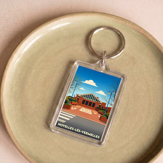 Porte-clés souvenir de la ville de Noyelles-lès-Vermelles avec une illustration stylisée.