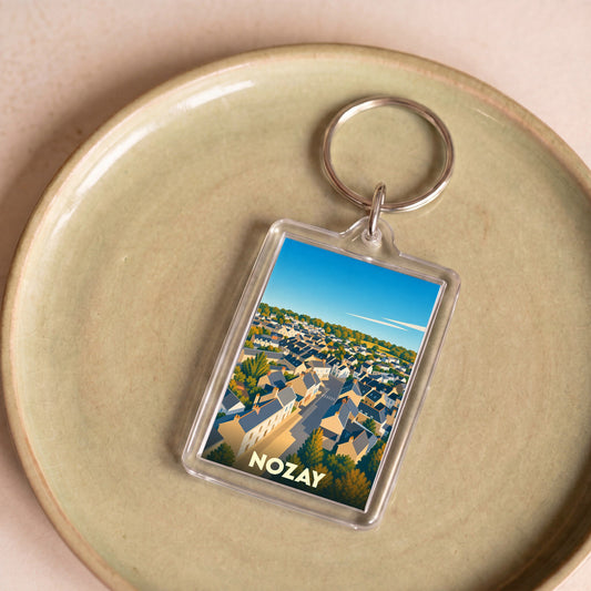 Porte-clés souvenir de la ville de Nozay avec une illustration stylisée.