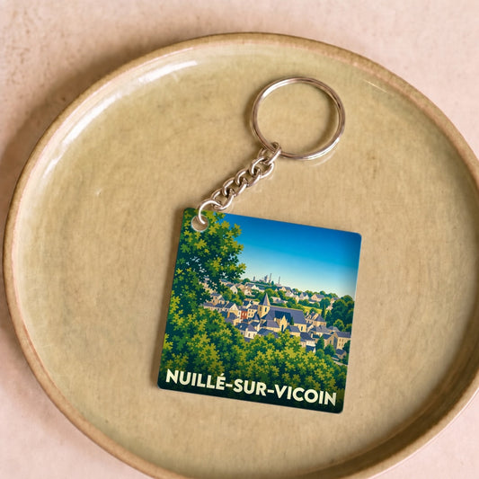Porte-clés souvenir de la ville de Nuillé-sur-Vicoin avec une illustration stylisée.