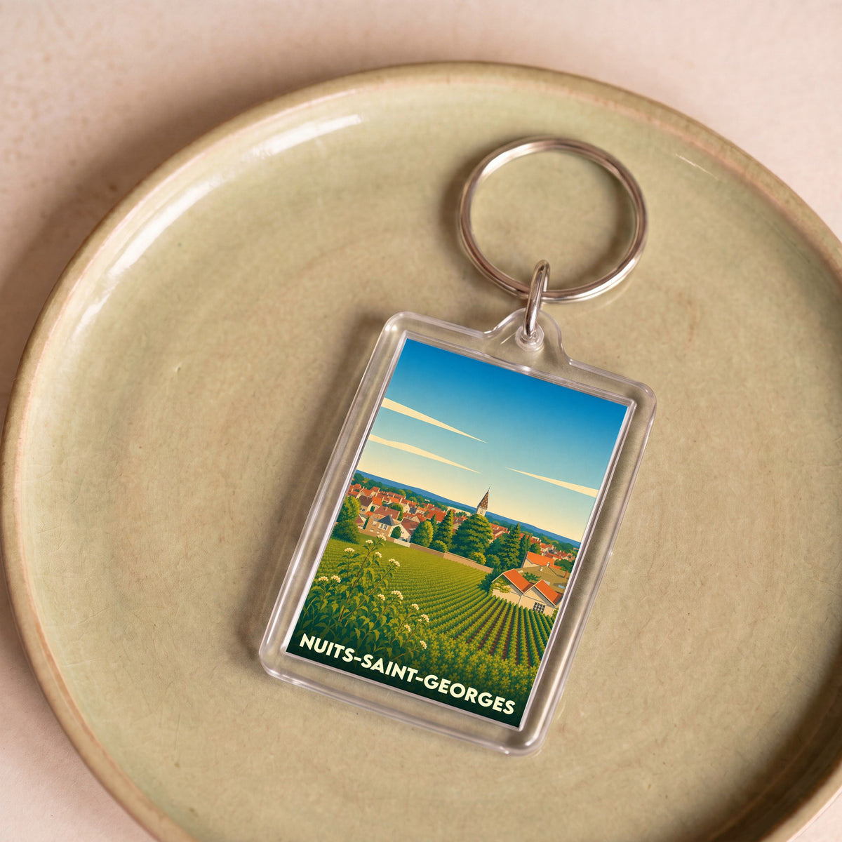 Porte-clés souvenir de la ville de Nuits-Saint-Georges avec une illustration stylisée de ses vignobles.