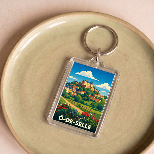 Porte-clés souvenir de la ville de Ô-de-Selle avec une illustration paysagère stylisée.