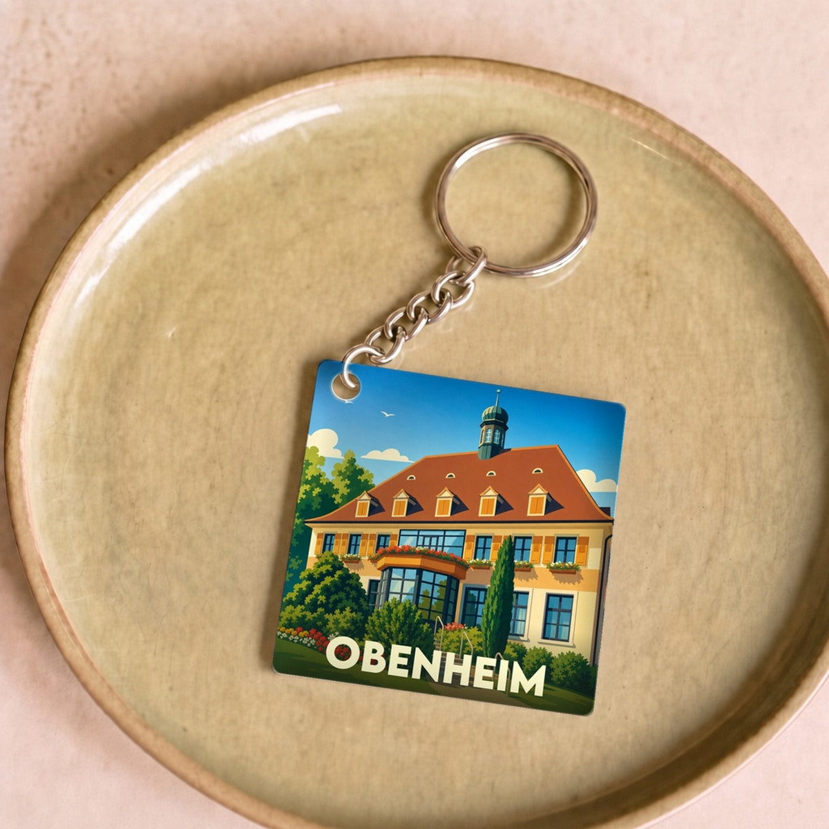 Porte-clés souvenir de la ville d'Obenheim avec une illustration stylisée de sa mairie.