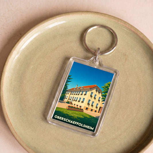Porte-clés souvenir de la ville d'Oberschaeffolsheim avec une illustration stylisée.